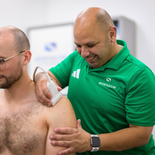 Arios Masso, Sportphysiotherapeut und sektoraler Heilpraktiker von der Physiotherapie-Praxis SPORTHICUM in Bergisch Gladbach beim Anwenden der Ultraschalldiagnostik Arios Masso, Sportphysiotherapeut und sektoraler Heilpraktiker von der Physiotherapie-Praxis SPORTHICUM in Bergisch Gladbach beim Anwenden der Ultraschalldiagnostik